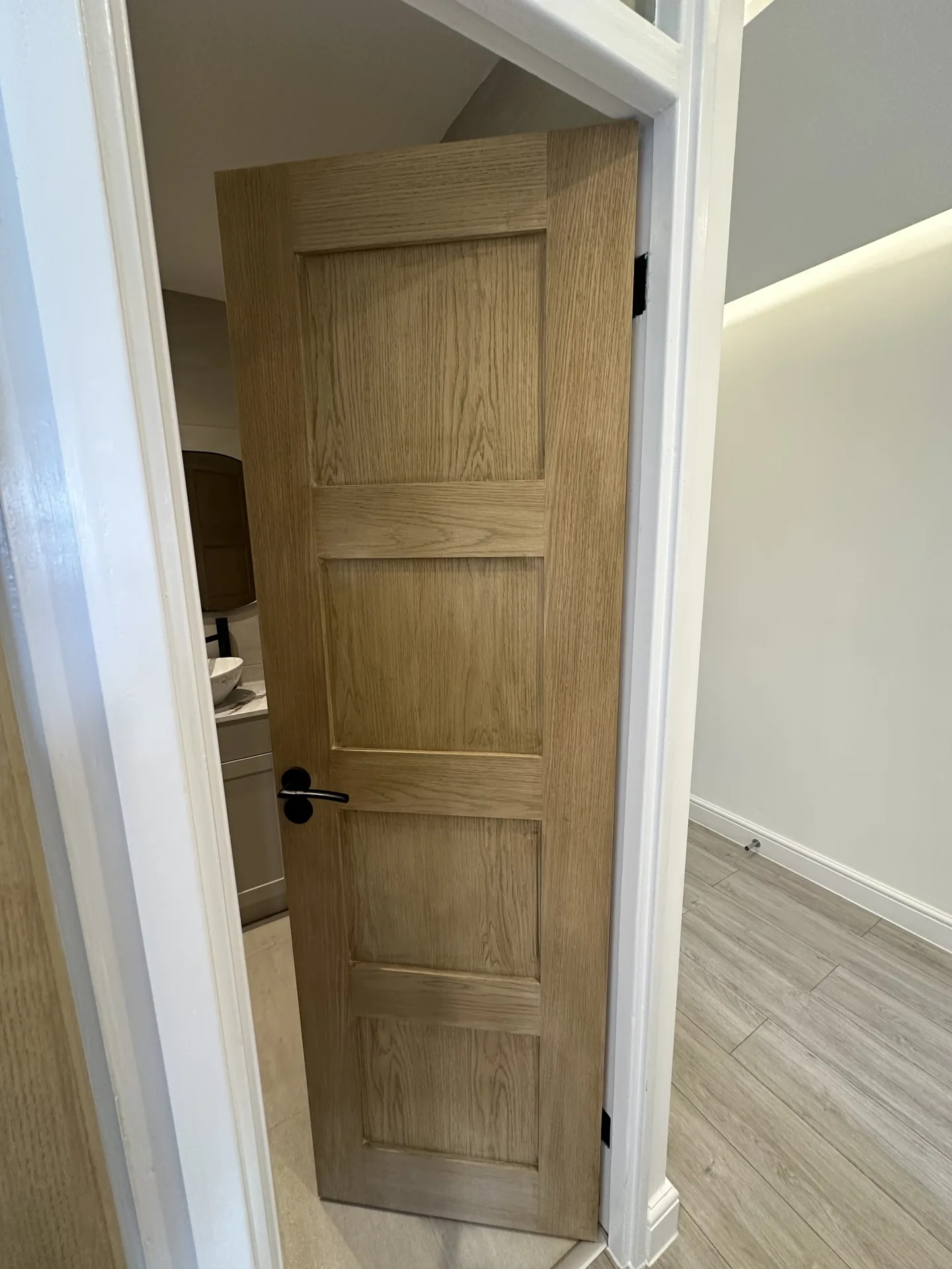 New oak panelled door with black ironmongery opening off the hallway