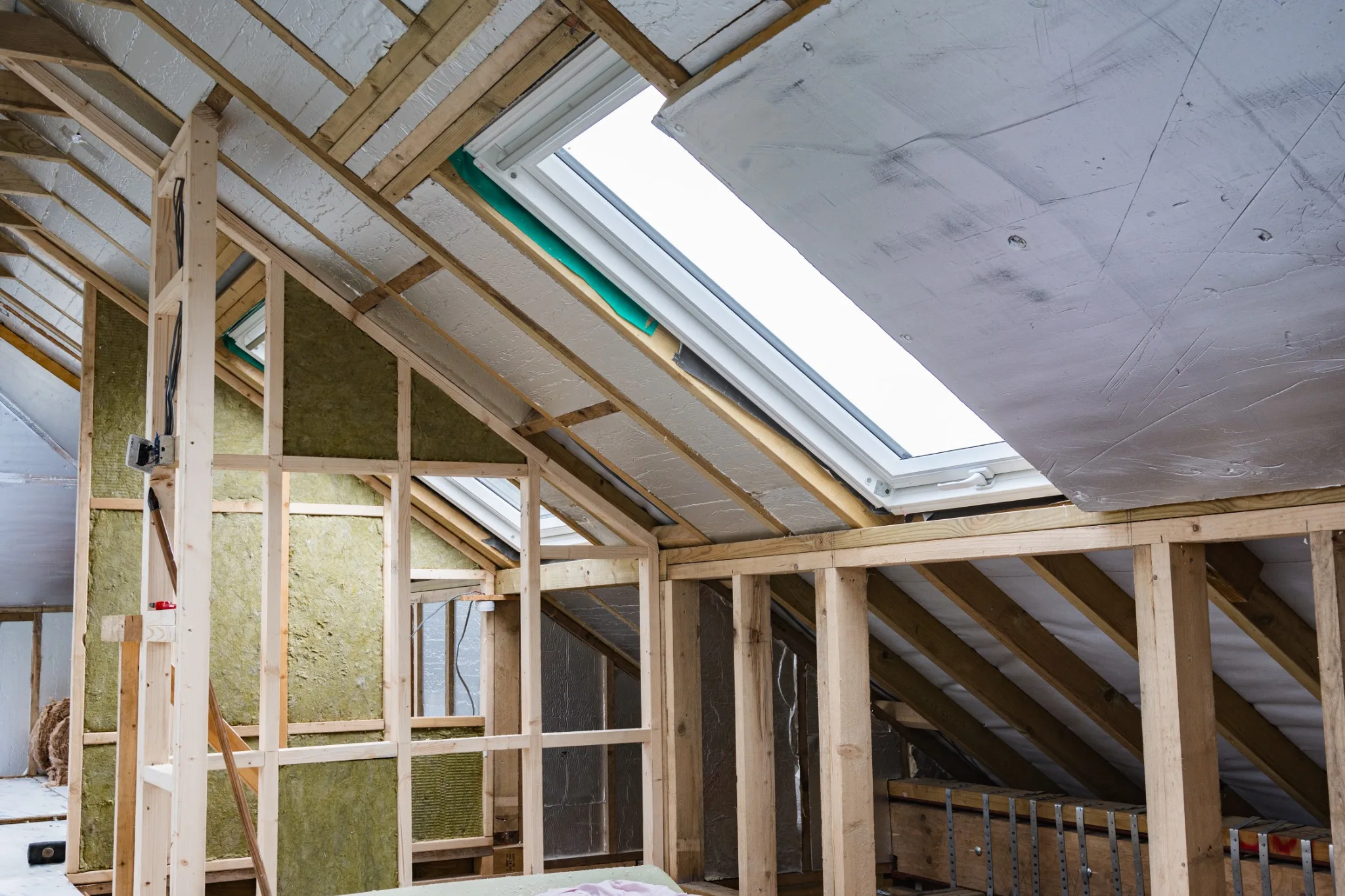 Loft roof structure with exposed timber framing, insulation and fitted roof windows