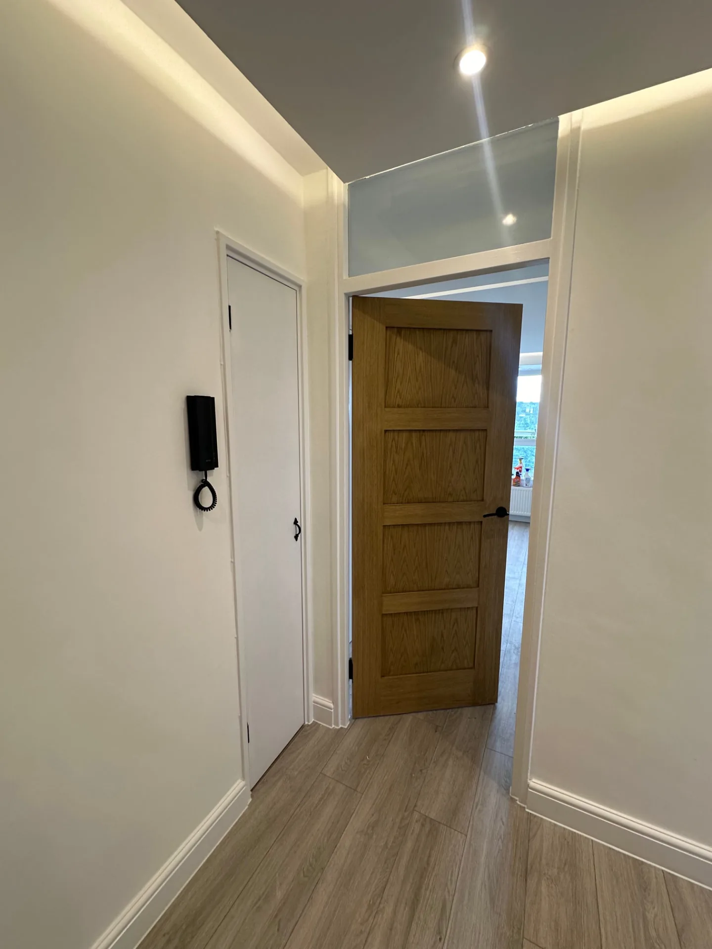 Hallway looking through an oak door into the lounge