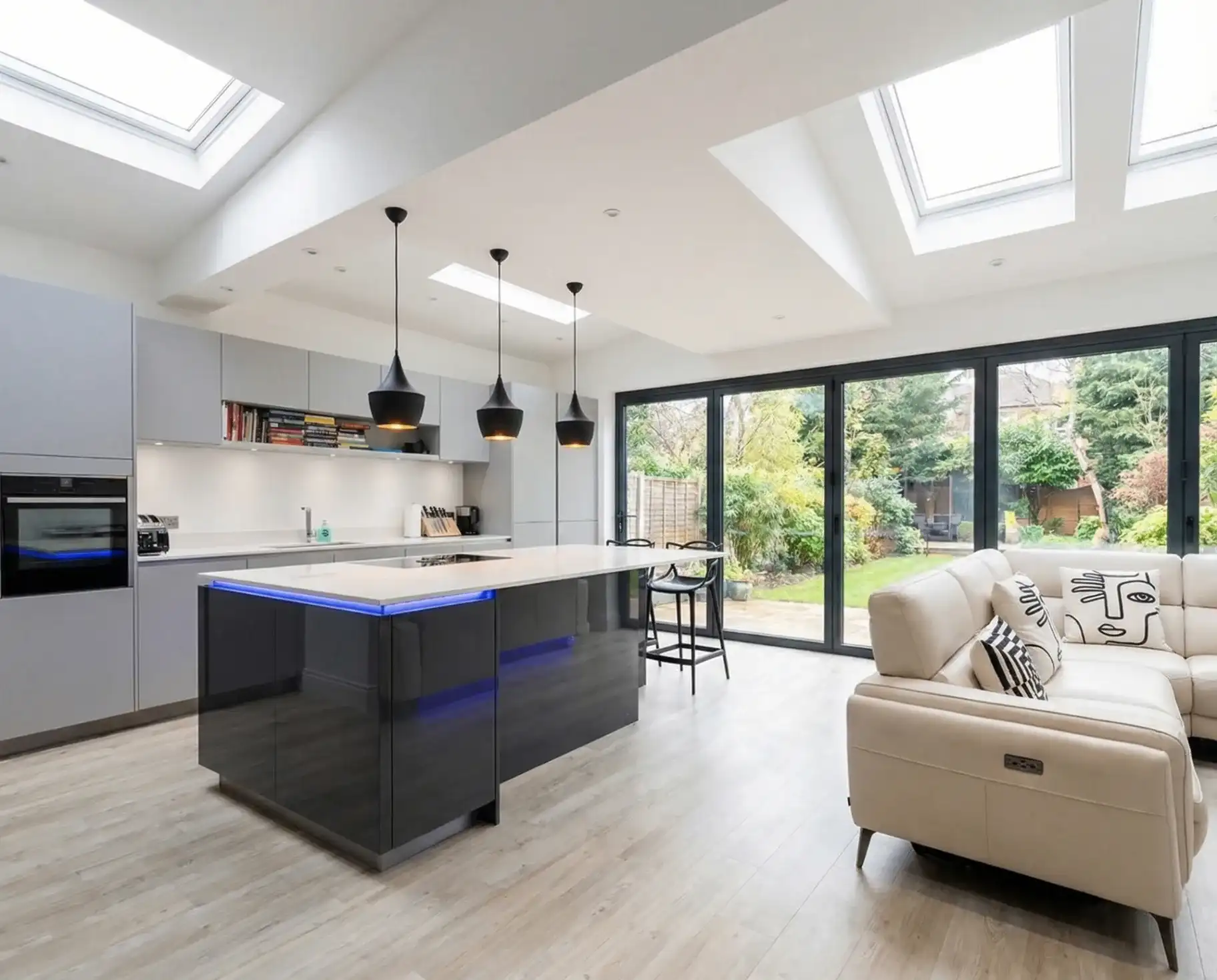 Modern open-plan kitchen extension in London with bifold doors, skylights and island — built by Trovix Group